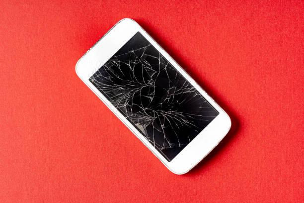 istock Broken mobile phone with cracked display on red background. 1312179365