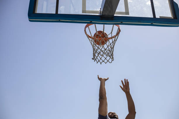 istock Low angle view of man taking a basketball shot 1312179478