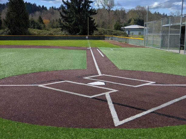 a large, empty baseball field on a bright, sunny day - baseball base baseball diamond field imagens e fotografias de stock