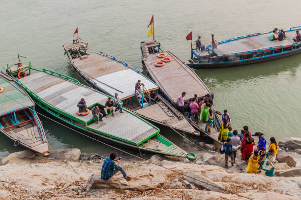 People boarding a boat at Peacock Umananda island in Brahmaputra river near Guwahati, Ind Guwahati, India - January  31, 2017: People boarding a boat at Peacock Umananda island in Brahmaputra river near Guwahati, India brahmaputra river stock pictures, royalty-free photos & images