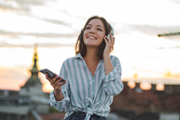 istock Young woman on the rooftop enjoying the sunset 1312183848