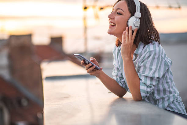 istock Young woman on the rooftop enjoying the sunset 1312184209