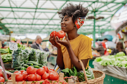 Joven africana comprando tomates en el mercado photo
