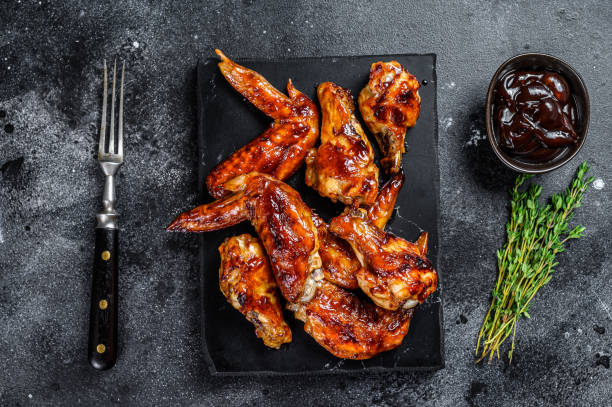 istock Hot Barbecue chicken wings with sauce bbq. Black background. Top view 1312184259