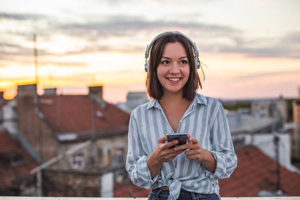 istock Young woman on the rooftop enjoying the sunset 1312184294