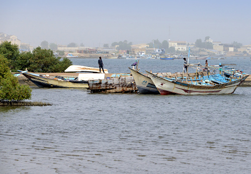 Massawa, Northern Red Sea Region, Eritrea: pier with subsistence fishing boats with the Gherar peninsula in the background - Edaga district, Gulf of Zula / Annesley Bay / Baia di Arafali, Red Sea.