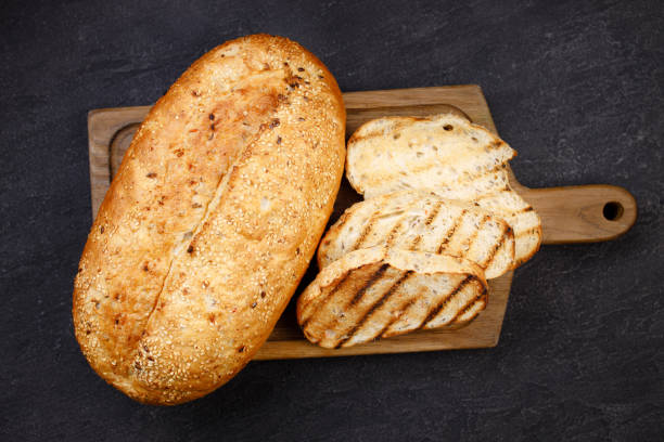 istock Freshly baked sliced wheat bread on cutting board 1312185614