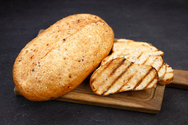 istock Freshly baked sliced wheat bread on cutting board 1312185680