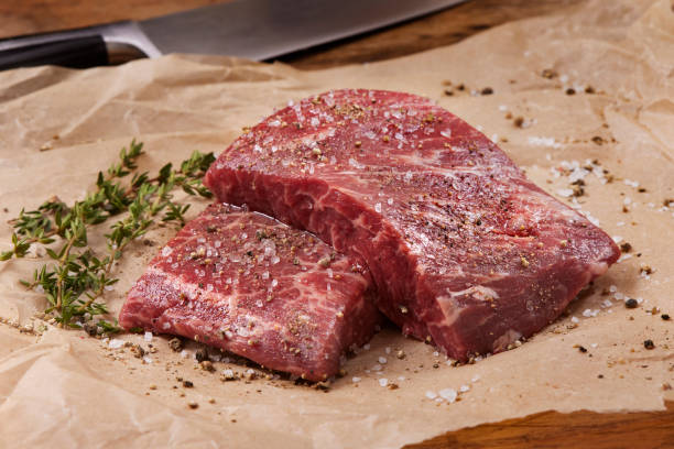 istock Seasoning Raw Flat Iron Steaks 1312187685