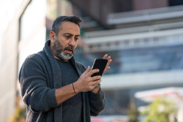 istock Upset man looking at his mobile phone 1312188971