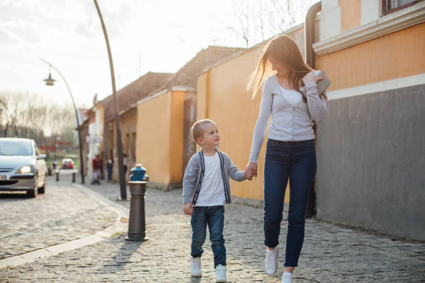 istock Mom And Her Son Walking In A City 1312189735