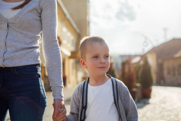 istock Mom And Her Son Walking In A City 1312189883