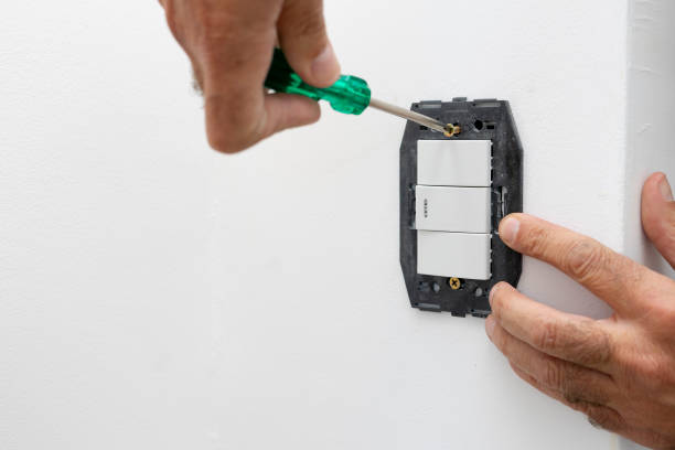 istock hands of a person mounting a home light switch with a screwdriver 1312190803