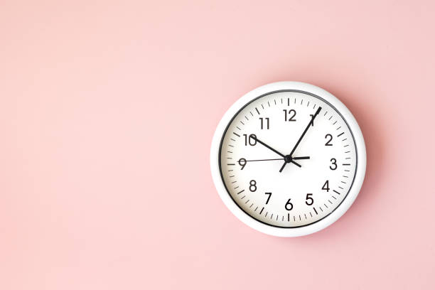 relógio, relógio de seta branca na mão de mulher de fundo branco segurando um relógio redondo com setas pretas - clock clock face blank isolated - fotografias e filmes do acervo