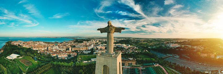 Aerial panoramic view of Sanctuary of Christ the King or Santuario de Cristo Rei at sunset. Christ Statue in Lisbon, Portugal. High quality photo