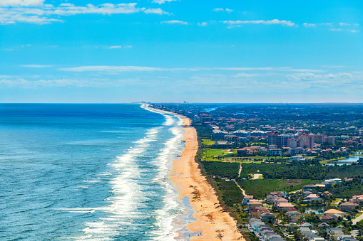 Wide angle aerial view of the stretch of beach from Ormond Beach to Daytona Beach, Florida shot from an altitude of about 1000 feet over the breaking waves.