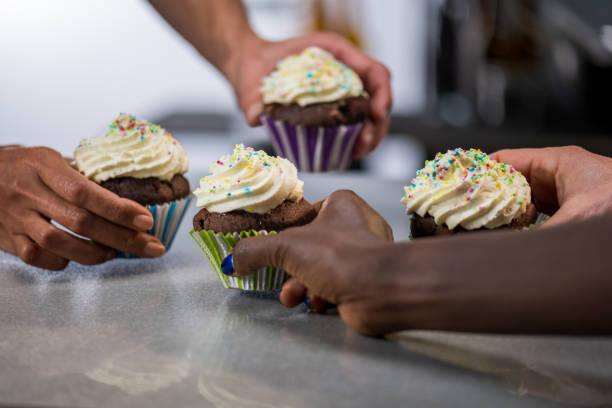 istock Multi-ethnic group of friends taking cream-filled cupcakes. 1312202222
