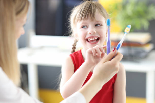 menina escolhendo escova de dentes no consultório do dentista - dentist family doctor dental hygiene - fotografias e filmes do acervo
