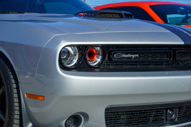 Front Dodge Charger Austin, Texas, USA. February 7, 2021. A dodge Challenger close up on the front headlight. was taken on a sunny day at a car show. a orange car in the back. dodge charger stock pictures, royalty-free photos & images