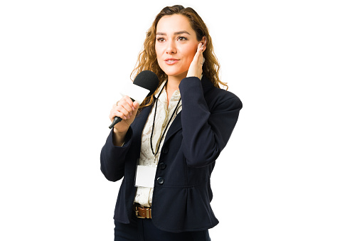 Female reporter working as a correspondent for the tv news. Young woman and journalist talking about breaking news with a microphone in front of a camera