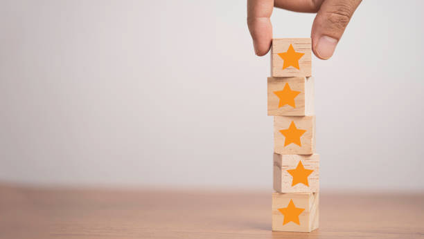 istock Hand putting yellow stars which print screen on wooden cube block  for customer satisfaction concept. 1312211683