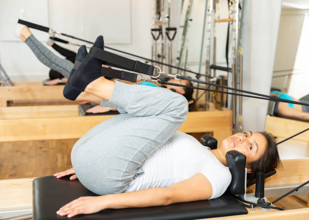 pilates femme étirant le sport dans le lit réformateur - pilates machine photos et images de collection