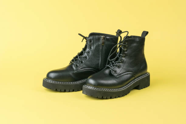 istock Leather brutal high-soled shoes with laces on a yellow background. 1312216807