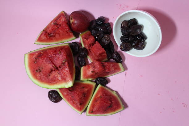 istock Watermelon and date fruit on bowl pink background 1312220518