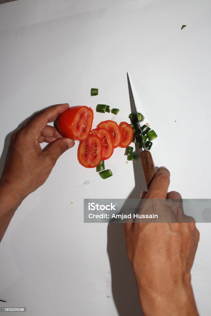 Man cutting tomato and hot pepper Adult Stock Photo Man cutting tomato and hot pepper Adult Stock Photo