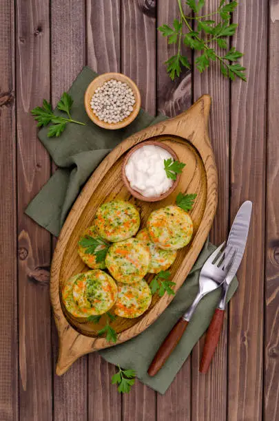 Fried vegetable cutlets with white sauce on a wooden background. Selective focus.