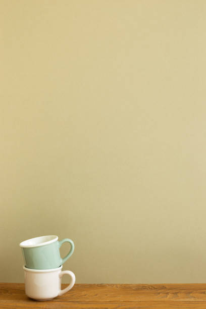 istock Stack of mug cup on wooden table. khaki beige background 1312224976
