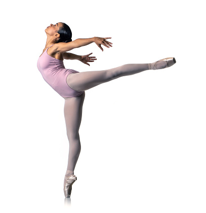 Ballerina stands in ballet arabesque