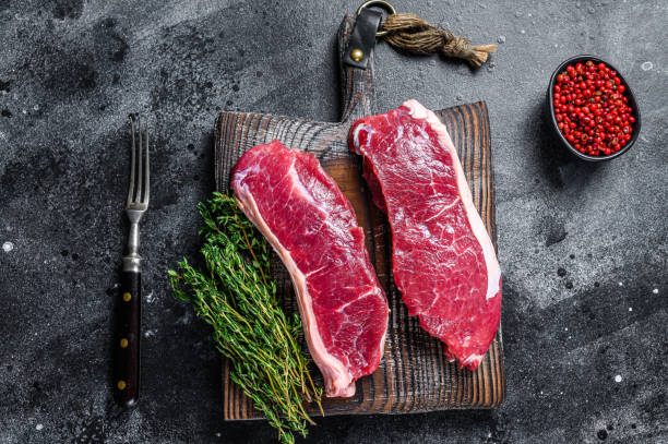 istock Raw marbled beef meat sirloin steak. Black background. Top view 1312226844