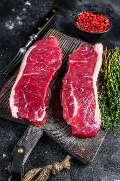 istock Raw marbled beef meat sirloin steak. Black background. Top view 1312226856