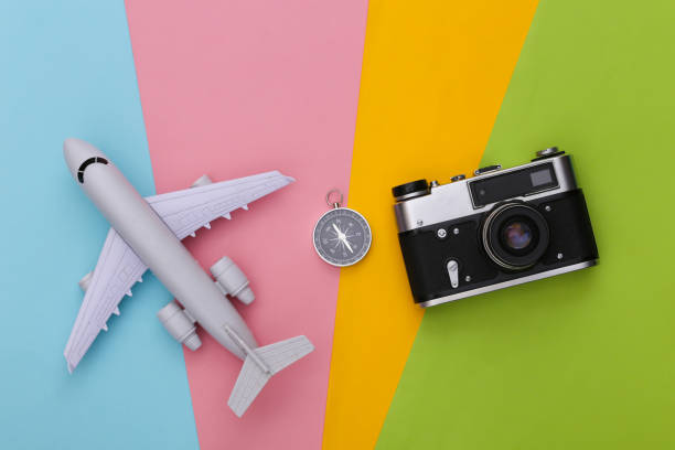 istock Compass, camera and air plane on colored background. Travel, adventure flat lay. Top view 1312230071