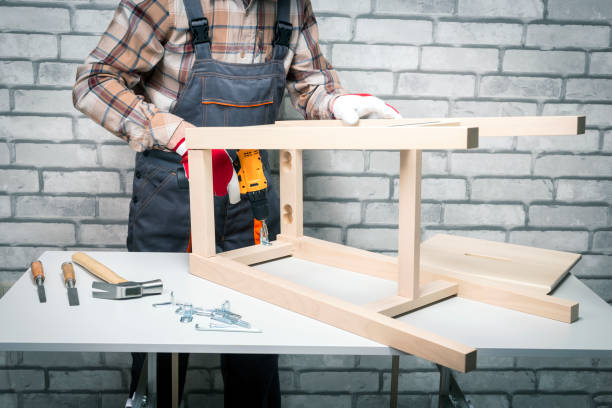 istock Man is working with furniture assembly using electric screwdriver. Repairman assembling the chair. DIY concept. 1312231405