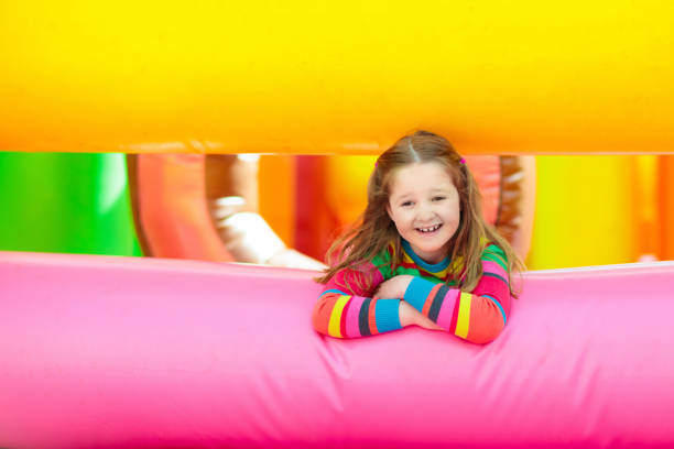 istock Child jumping on colorful playground trampoline 1312231431