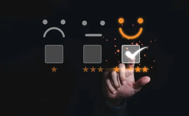Photo of Businessman touching and doing mark to select smiley face with five yellow stars on black background, the best customer satisfaction and evaluation for good quality product and service.