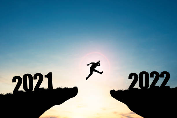 istock Silhouette man jumping from 2021 cliff to 2022 cliff with blue sky and sunlight, preparation new challenge business target and life for new year. 1312232348