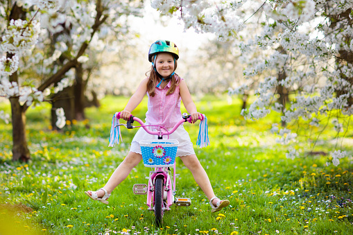 Happy girl putting cycle helmet on.