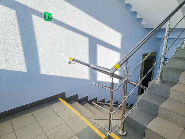 istock modern metal staircase.Looking down at a modern staircase with white wall as to be found in an office, hospital or an apartment.sunny day.yellow line helps visually impaired the indoor stairway 1312232433