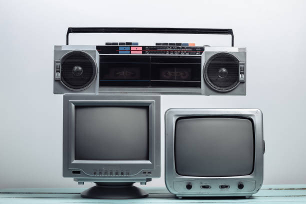istock Two old tv receiver with audio tape recorder on a white wall background. Retro media 1312233582