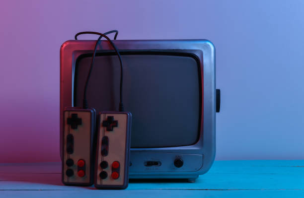 istock Old tv receiver with retro joysticks in red blue neon light. Retro gaming. 80s 1312233650