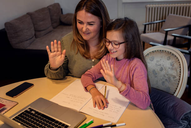 istock Mother and daughter follow online classes using laptop at home. 1312234453
