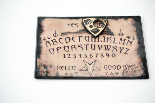 istock Mystic ritual with Ouija on white background. Devil's board concept, black magic or fortune telling rite with occult and esoteric symbols. Mystical rituals and occult sciences. 1312235641