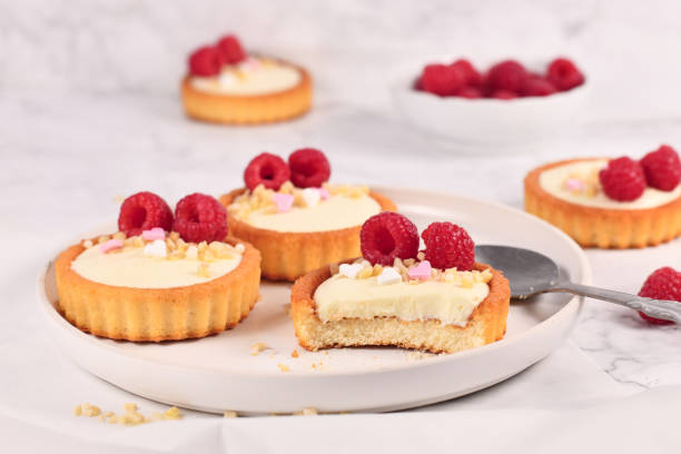 istock Small tartlet pastries with white cream, topped with raspberry fruits 1312235845