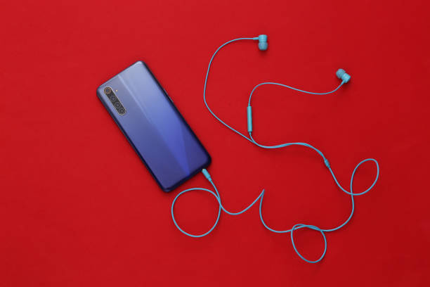 istock Modern smartphone with blue earphones on red background. Top view. 1312236919