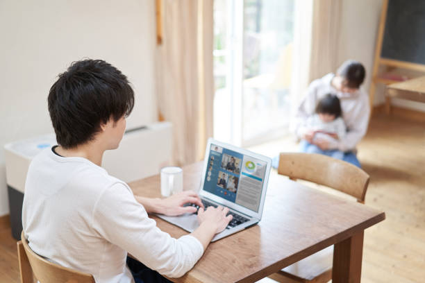 在宅勤務に関するオンライン会議を持つアジア人男性 - コワークスペース ストックフォトと画像