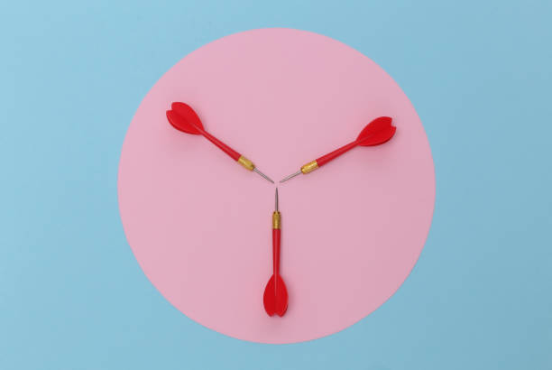 istock Three red plastic darts with metal tip on blue pastel background with pink circle. Top view. Flat lay. Minimalism 1312238888