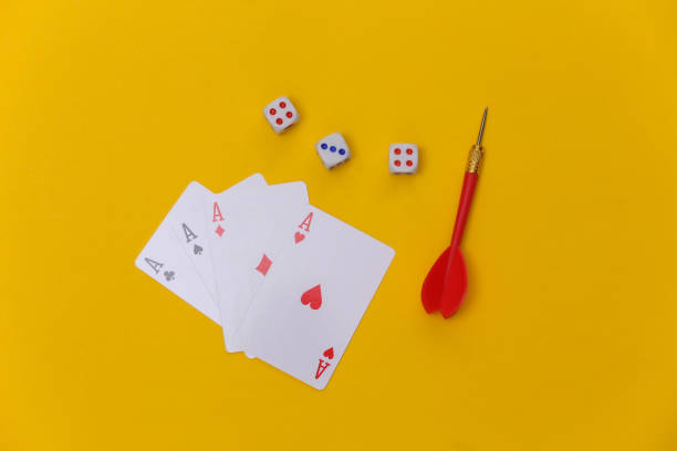 istock Gambling. Four aces, dice and darts on a yellow background. Top view 1312238925